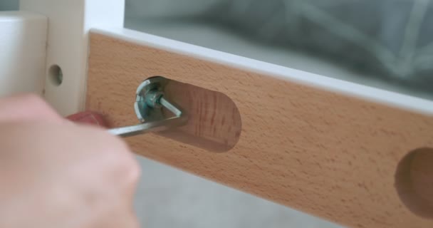 Primer plano. alguien atornilla un tornillo con un destornillador en una muesca en una tabla de madera — Vídeo de stock