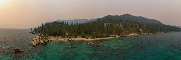 ネバダ州のタホ湖に沿った秘密の入り江カリフォルニアの近くの森林火災のためにぼんやりとした空 — ストック写真