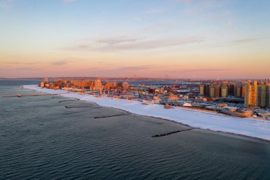 Kışın Brooklyn, New York 'ta güneş doğarken Coney Island Sahili' ni kaplayan kar manzarası