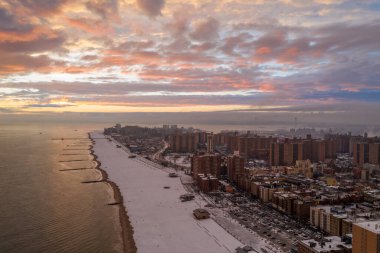 Brooklyn, New York 'ta kış günbatımında Coney Island Sahili' ni kaplayan kar manzarası
