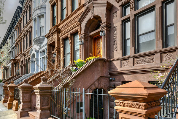 New York City - Apr 10, 2021: View of Brownstone buildings in Harlem in Manhattan, New York City.