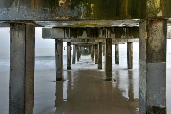 Sotto il molo sulla spiaggia — Foto Stock