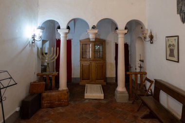 Sorano, İtalya - 13 Temmuz 2025: Sorano, İtalya 'daki Küçük Sinagog' un İçi. Kemerli kolonlar, ahşap banklar ve bir menorah..