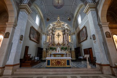 Pitigliano, İtalya - 13 Temmuz 2025: Pitigliano, İtalya 'daki Jubilee Kilisesi' nin mermer mihrabında, Barok mimarisinin karmaşık ayrıntıları ve büyük yan pencerelerden hafif öğleden sonra aydınlatmaları yer alıyor.