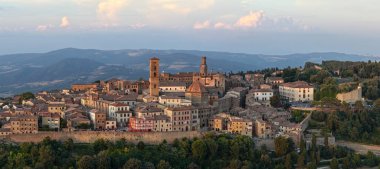 Tuscany 'deki ortaçağ Volterra' sının hava görüntüsü gün batımında Apennine tepelerinin üzerinde taş duvarlar, terasotta çatıları ve kuleleri gösteriyor..