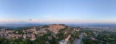 Tuscany 'deki Ortaçağ Tepesi Volterra' nın hava manzarası taş evleri, terracotta çatıları ve gün batımında yuvarlanan kırsal bölgeleri gösteriyor..