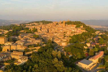 Volterra Tepesi 'nin altın saatinde Toskana' daki ortaçağ kasabasının havadan görünüşü taş binaları, savunma duvarlarını ve kırsal bölgeleri gösteriyor..