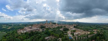 Ortaçağ Volterra 'sının hava günbatımı manzarası, Tuscan tepeleri üzerinde yükselen taş duvarları ve kuleleri ve çevresindeki kırsal bölgeler..
