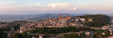 Ortaçağ Volterra 'sının hava günbatımı manzarası, Tuscan tepeleri üzerinde yükselen taş duvarları ve kuleleri ve çevresindeki kırsal bölgeler..