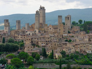 San Gimignanos ortaçağ taş kulesinin havadan görünüşü ve Toskana 'da güçlendirilmiş tepe şehir silüeti bulutlu yaz ışığı altında..
