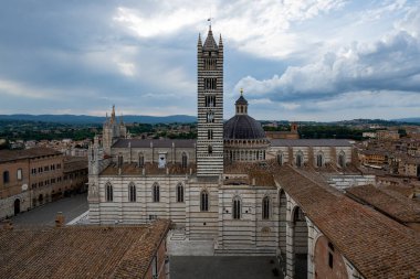 Siena Katedrali 'nin havadan görünüşü, belirgin beyaz ve yeşilimsi mermer çizgileri olan Gotik bir başyapıt, muhteşem bir kubbe ve çan kulesi içeriyor..