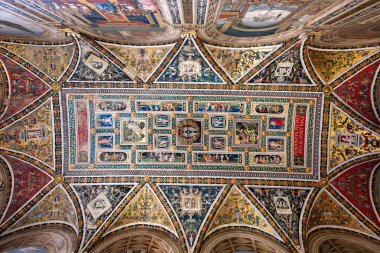 Siena, İtalya - 19 Temmuz 2025: Rönesans freskleri İtalya 'nın Siena kentindeki Piccolomini Kütüphanesi' nin zengin dekore edilmiş tavanını süslüyor. Papa 2. Pius 'un yaşamının parlak mavi ve altın rengi sahneleri