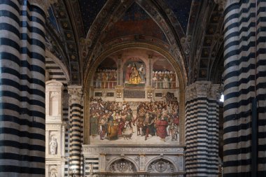 Siena, İtalya - 19 Temmuz 2025: Siena Katedrali 'nin karmaşık iç mekanlarında çizgili mermer sütunlar ve freskler sergilenmekte ve İtalya' nın Siena kentinde Gotik mimari sergilenmektedir..