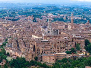 İkonik Gotik bir başyapıt olan Siena Katedrali, İtalya 'nın Siena kentindeki kırmızı tuğlalı ortaçağ binaları arasında yükseliyor. Karmaşık maskaralıklarıyla ve çizgili mermer sütunlarıyla bilinir.