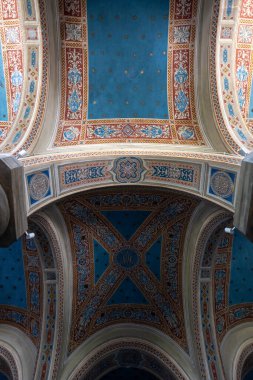 Pienza, İtalya - 18 Temmuz 2025: San Francesco, Pienza Kilisesi 'ndeki karmaşık boyanmış tavan kemerlerinin görüntüsü. Zengin kırmızı, mavi ve altın desenler.