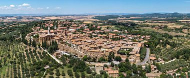 Pienza, İtalya 'nın hava manzarası, Rönesans kentsel planlaması sergileniyor. Gökyüzü kırmızı kiremitli çatılar ve açık bir yaz gökyüzü altında canlı Toskana manzaraları arasında Pienza Katedrali yer alıyor..