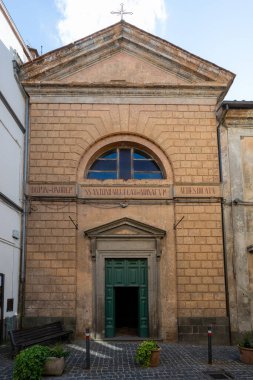 Acquapendente, İtalya 'daki Azizler Kilisesi' nin taş cephesi Anthony Abbot ve Catherine. Romanca mimari, yeşil ahşap kapı, kemerli pencere ve oymalı metin..