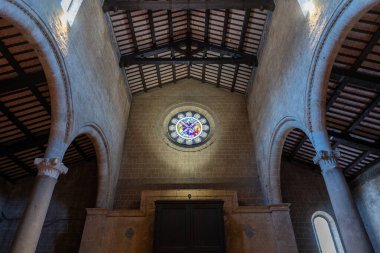 Orvieto, İtalya - 14 Temmuz 2025: Sant 'Andrea, Orvieto Kilisesi' nin Gotik tarzı nave, tırtıklı mahzenleri, taş sütunları, karmaşık kürsüsü ve loş doğal ışık.