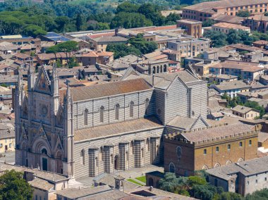 1290 'dan inşa edilen Gotik Orvieto Katedrali, çizgili mermer cephesi ve gül penceresiyle kasabaya hükmediyor. Hava görüntüsü karmaşık şehir planlarını, terracotta çatılarını, bereketli Umbrian manzarasını gözler önüne seriyor..