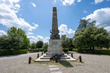 San Gimignano, İtalya - 22 Temmuz 2025: Taş Dikili Savaş Anıtı San Gimignano 'da çakıllı bir plazada Parlak bir gökyüzü altında düşen askerleri onurlandırdı.