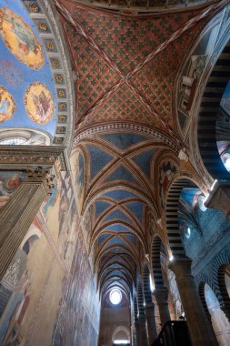San Gimignano, İtalya - 22 Temmuz 2025: Gotik kaburga kasaları ve ortaçağ Toskana 'sında Romen Duomo di San Gimignano içinde 14. yüzyıl freskleri.