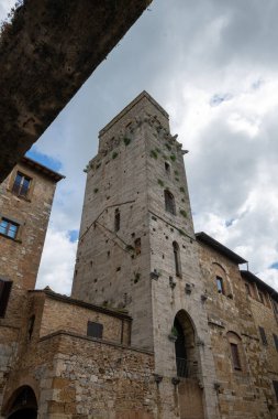 San Gimignano 'daki ortaçağ taşı Torre del Diavolo' nun alçak açılı manzarası. Tuscan 'ın 13. yüzyıldan kalma kuleleri ile ünlü bir tepe kasabası..