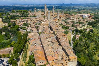 Ortaçağ San Gimignano, Toskana 'nın havadan görünüşü taş kule evleri, terasotta çatıları ve tepenin tepesindeki güçlendirilmiş duvarları gösteriyor..