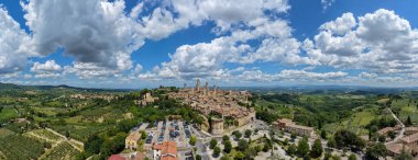 San Gimignanos ortaçağ taş kulelerinin hava manzarası Toskana üzüm bağları ve arabasız duvarlar üzerinde yükseliyor, Via Francigena 'daki tarihi komün.