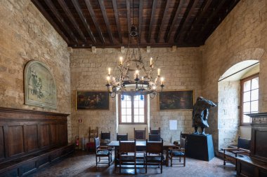 Volterra, İtalya - 21 Temmuz 2025: Palazzo dei Priori, Volterra 'daki ortaçağ konseyi, taş duvarlar, ahşap tavan, avizeler, tarihi tablolar ve bronz heykel.