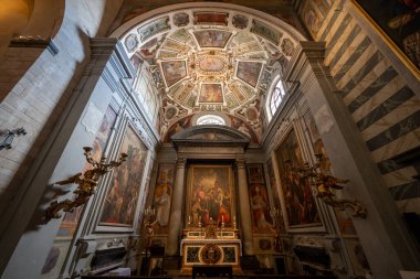 Volterra, İtalya - 21 Temmuz 2025: Volterra Katedrali 'ndeki Barok şapeli, boyalı katlı kasa, yaldızlı melekler, büyük sunak ve yumuşak pencere ışığı altında mermer sunak.