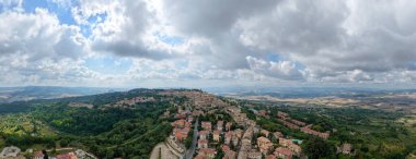 Tuscany 'deki ortaçağ volterlerinin hava manzarası, yoğun taş mimarisini, etrafındaki ormanları ve bulutların altındaki tarımsal vadileri gösteriyor..