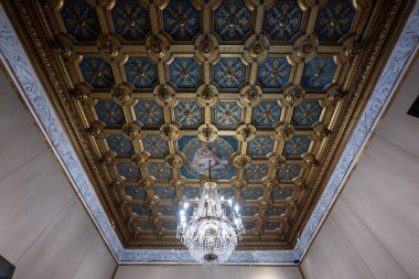 Mantua, İtalya - 25 Temmuz 2025: İtalya 'nın Mantua kentindeki tarihi Ducale Sarayı' nda merkezi dini fresk ve kristal avizeyle süslü altın kaplama tavan.