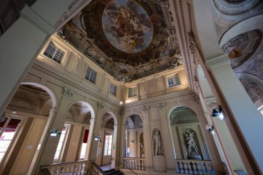 Bologna, İtalya - 23 Temmuz 2025: Bolonya 'daki Palazzo Ercolani' nin büyük merdiveni, neoklasik kemerler, mermer heykeller ve süslü Barok tarzı tavan fresklerinin yer aldığı.