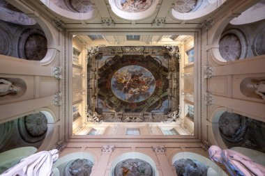 Bologna, İtalya - 23 Haziran 2025: Palazzo Ercolani 'deki fresk avlu tavanı ve heykellerin yukarıdan görünüşü, Barok dekoratif sıva ve anıtsal mimarinin altını çiziyor.