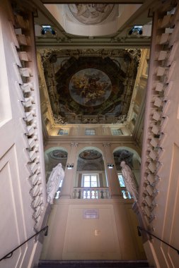 Bologna, İtalya - 23 Temmuz 2025: Bologna 'daki tarihi aristokratik konut olan Palazzo Ercolani' nin içindeki büyük merdiven manzarası ve Barok tavanı.