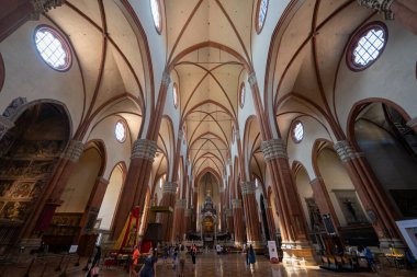 Bologna, İtalya - 23 Temmuz 2025: Bolonya 'daki San Petronio Bazilikası' nın geniş açılı manzarası, tırtıklı mahzenleri, taş sütunları ve ziyaretçileri ile.