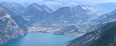 Garda Gölü 'ndeki Riva del Garda üzerinde yüksek hava manzarası dik Alp kayalıkları, buzul gölü havzası ve ekili vadi tabanını gösteriyor..