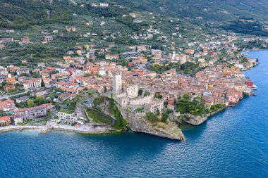 Castello Scaligero ve ortaçağ Malcesine 'nin havadan görünüşü yaz ışığında Gardas Gölü' nün kıyısında kayalık bir çıkıntıda kümelendi..