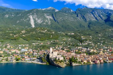 Ortaçağ Malcesine 'inin yukarısındaki Castello Scaligero' nun havadan görünüşü Garda Gölü 'nde, Monte Baldo' nun orman yamaçları tarafından destekleniyor..