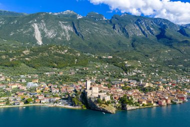Castello Scaligero 'nun, Monte Baldo' nun dik yamaçlarının altındaki terracotta çatıları ile Garda Gölü 'ndeki Malcesine' e hâkim olduğu hava manzarası..