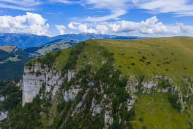 Malcesine yakınlarındaki Monte Baldo 'nun havadan görünüşü kireçtaşı kayalıkları, dağlık çayırları ve yaz bulutlarının altındaki uzak Dolomite tepelerini gösteriyor..