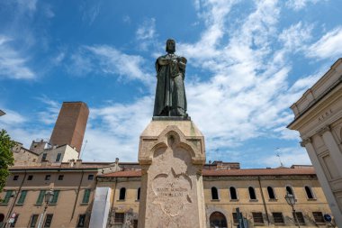 Mantua, İtalya - 26 Temmuz 2025: Floransalı şairin onuruna ortaçağ tuğla binaları ve yaz gökyüzü tarafından çerçevelenen bir Mantua meydanında Dante Alighieri 'nin taş anıtı.