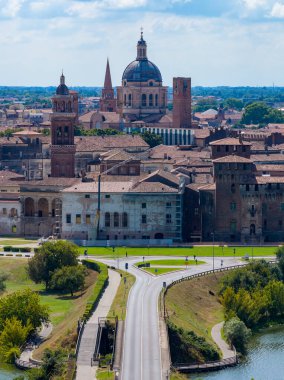 Aerial view over Mantua showing terracotta roofs, church towers and the dome of Basilica of SantAndrea beside the lakeside causeway.