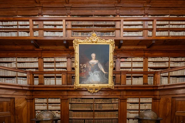 Mantua, İtalya - 26 Temmuz 2025: Mantua 'da 18. yüzyıl Biblioteca Teresiana' sının ahşap panelli okuma odası, tabandan tavana raflar ve merkezi bir barok portresi.
