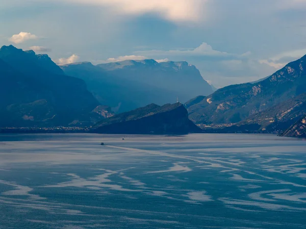 Garda Gölü 'nden Malcesine' e doğru hava manzarası. Yazın geç saatlerinde sisli Alp sırtları tarafından çerçevelenmiş..