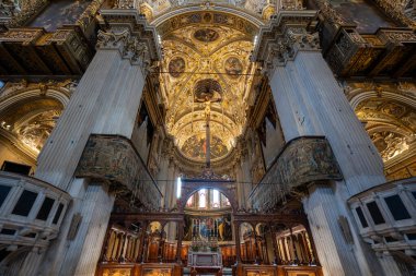 Bergamo, İtalya - 30 Temmuz 2025: Bergamo 'daki Basilica di Santa Maria Maggiore' un Barok iç mimarisi, freskli kasalar, mermer sütunlar, oyulmuş koro tezgahları ve süslü duvar halıları.