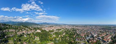 Bergamo 'nun yüksek hava manzarası, güçlendirilmiş Citt Alta yamaçlarının, Venedik duvarlarının ve yazın gökyüzü altında genişleyen modern bölgelerin olduğunu gösteriyor..