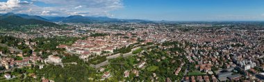 Aerial panorama of Bergamo showing fortified Citt Alta hilltop district, Venetian walls, terracotta roofs and sprawling modern lower city