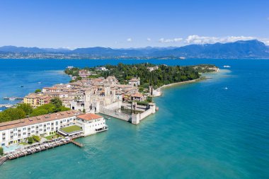 Ortaçağ sokakları, göl kenarındaki villalar ve uzak Alp dağlarıyla Garda Gölü 'ne uzanan tarihi Sirmione yarımadasının hava manzarası..
