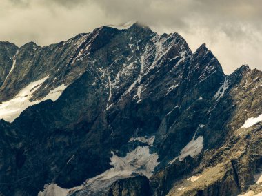 Valtournenche 'nin üstündeki kayalık Testa Grigia zirvesine yakın telefon görüşü, koyu alp kayalıkları, kar tarlaları ve yaz sonu buzul kalıntılarını gösteriyor..